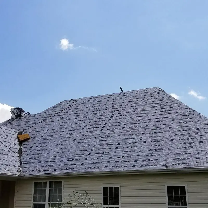 Synthetic underlayment installed on a hip roof before shingles