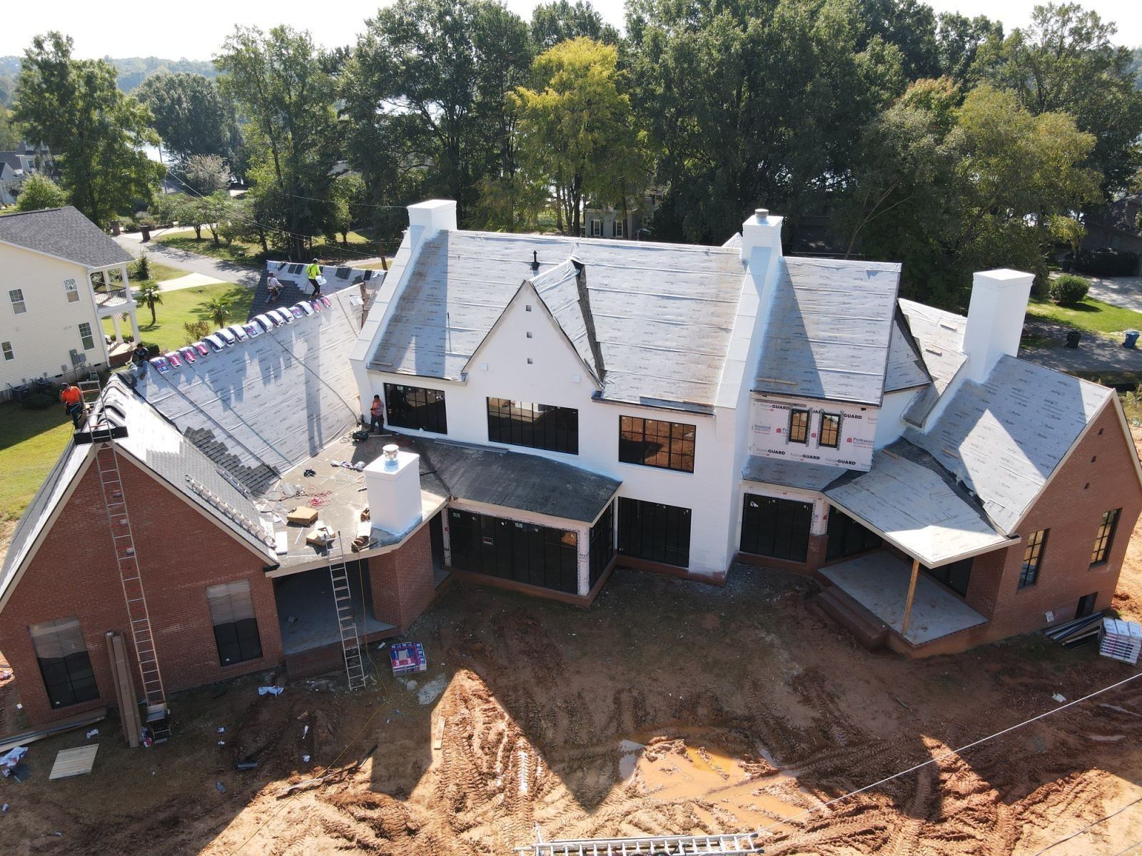 Aerial view of shingle installation on a large custom home
